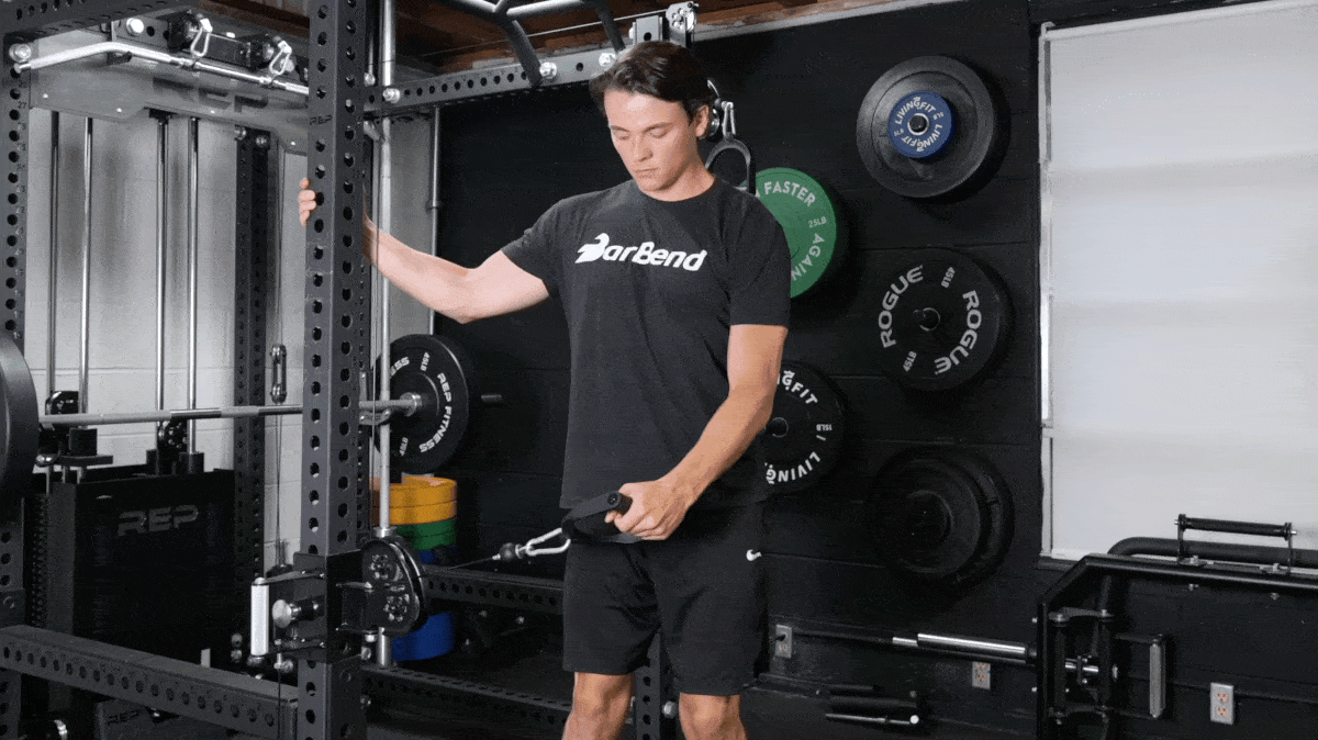 BarBend's Jake Herod performing the cable lateral raise exercise.