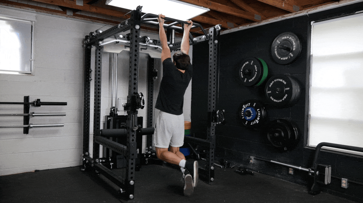 BarBend's Jake Herod doing a chin-up using a pull up bar.