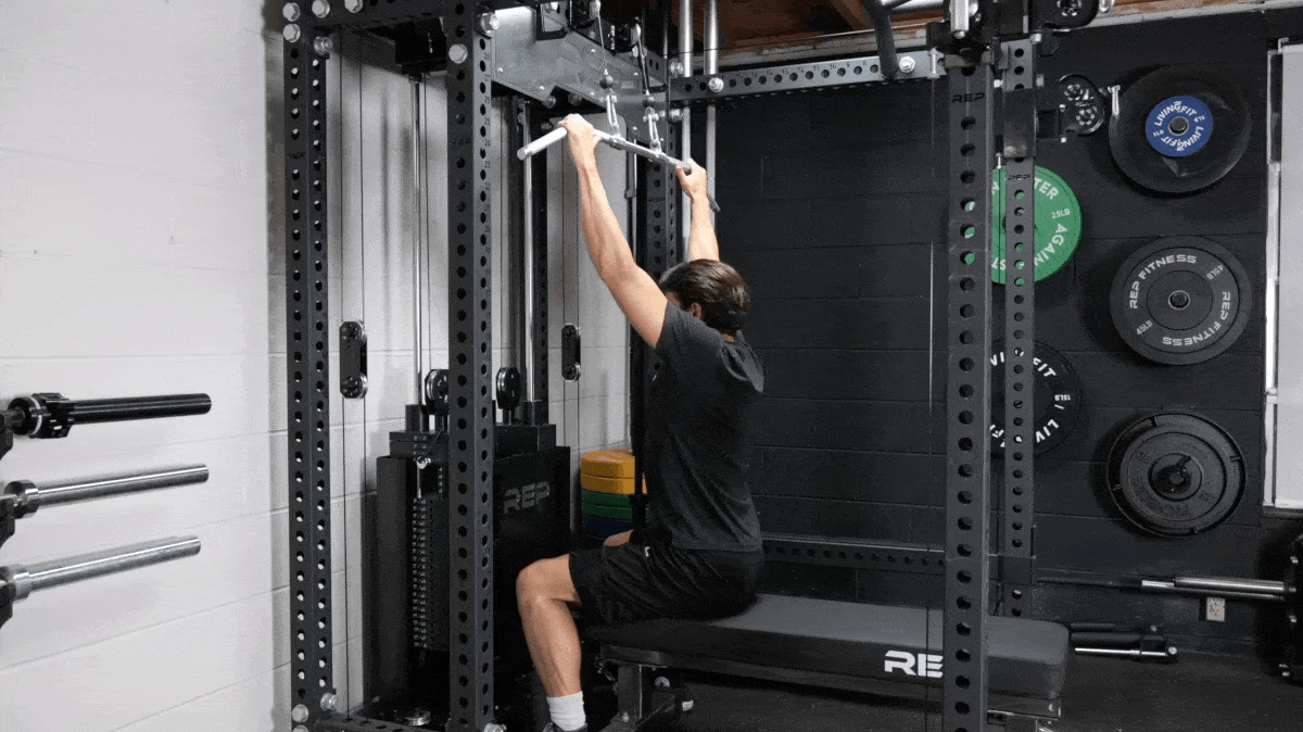 A person doing a lat pulldown with a cable machine.