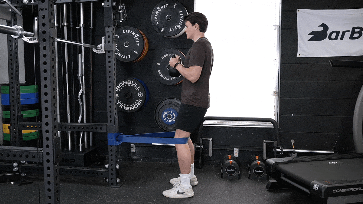 BarBend's Jake Herod doing the Spanish squat movement.