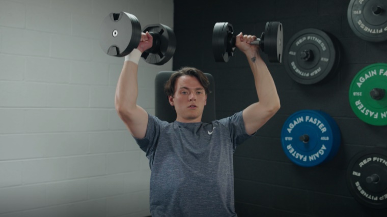 A BarBend tester trying the NÜOBELL Adjustable Dumbbells.